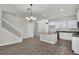 Open-concept living space with tile flooring, a granite kitchen island, and a staircase leading to the second floor at 18058 Cider Mill Ln, Winter Garden, FL 34787