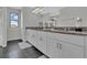 Well-lit bathroom with dual sinks, granite countertops, modern wood-style floors, and neutral color palette at 18076 Cider Mill Ln, Winter Garden, FL 34787