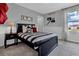 Tastefully decorated bedroom with baseball accents, a black bed frame, and plush carpeting at 18076 Cider Mill Ln, Winter Garden, FL 34787