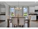 Dining area with chandelier lighting, large windows, and neutral-toned decor for elegant meals at 18076 Cider Mill Ln, Winter Garden, FL 34787