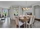 Open dining room featuring contemporary chandelier, views to outside and seamlessly attached to kitchen at 18076 Cider Mill Ln, Winter Garden, FL 34787