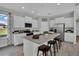 Bright kitchen with granite island, stainless steel appliances, white cabinets, and modern stools at 18076 Cider Mill Ln, Winter Garden, FL 34787