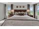 Bright, airy bedroom featuring large windows with a view, accent tables, and soft grey tones at 18076 Cider Mill Ln, Winter Garden, FL 34787