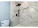 Elegant walk-in shower featuring modern fixtures and stylish marble-look tile at 1905 Diamond Dr, Orlando, FL 32807