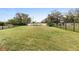 A large fenced backyard features lush green grass, offering ample space for recreation at 2017 Flora Pass Pl, Kissimmee, FL 34747