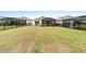 Spacious backyard with green lawn, black fence, and screened patios enhancing outdoor living at 2017 Flora Pass Pl, Kissimmee, FL 34747