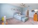 Blue bedroom has ceiling fan, neutral carpet, bench, and picture molding for a calming and comfortable space at 2017 Flora Pass Pl, Kissimmee, FL 34747