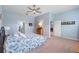 Calming blue bedroom with large bed, ceiling fan, and two doorways leading to the Primary bath and dining room at 2017 Flora Pass Pl, Kissimmee, FL 34747