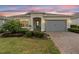 Charming single-story home with a well-maintained lawn, manicured shrubs, and a brick paved driveway at 2017 Flora Pass Pl, Kissimmee, FL 34747