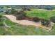 Aerial view of a lush golf course with manicured greens, sandy bunkers, and mature trees at 2017 Flora Pass Pl, Kissimmee, FL 34747