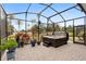Enclosed lanai with a hot tub, brick paver flooring, and tropical landscaping for a relaxing outdoor experience at 2017 Flora Pass Pl, Kissimmee, FL 34747