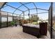 Enclosed lanai with a hot tub, brick paver flooring, and tropical landscaping for a relaxing outdoor experience at 2017 Flora Pass Pl, Kissimmee, FL 34747