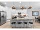 Bright kitchen boasts white cabinets, granite counters, stainless appliances, and stylish pendant lighting at 2017 Flora Pass Pl, Kissimmee, FL 34747