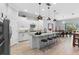 Well-lit kitchen features white cabinets, stainless steel appliances, and a granite countertop island at 2017 Flora Pass Pl, Kissimmee, FL 34747