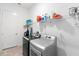 Well-equipped laundry room featuring washer, dryer, and plenty of shelving for supplies at 2017 Flora Pass Pl, Kissimmee, FL 34747