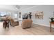 Bright living area with hardwood floors, leather furniture, bar seating, and sliding glass doors to the outdoor patio at 2017 Flora Pass Pl, Kissimmee, FL 34747
