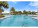 A pool features clear water and a gradual entry, surrounded by lush greenery and comfortable lounging areas at 2017 Flora Pass Pl, Kissimmee, FL 34747