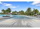 A zero entry community pool surrounded by lounge chairs and tropical palm trees, perfect for outdoor recreation at 2017 Flora Pass Pl, Kissimmee, FL 34747