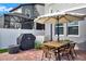 Outdoor dining area with an umbrella-shaded table and grill at 2320 Treasure Hill St, Clermont, FL 34715