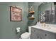 Stylish powder room featuring a gray vanity with white countertop and decorative accents at 2320 Treasure Hill St, Clermont, FL 34715