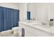 Modern bathroom features double vanity with white quartz countertop, blue accent shower curtain and chrome fixtures at 2320 Treasure Hill St, Clermont, FL 34715