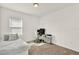 This spare bedroom features neutral decor, with a twin bed, desk, white chair and a wall of windows at 2320 Treasure Hill St, Clermont, FL 34715