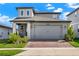 Charming two-story home featuring a two-car garage, brick driveway, and well-maintained landscaping at 2320 Treasure Hill St, Clermont, FL 34715