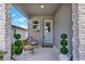 Inviting front porch with decorative potted plants, wicker chairs, and a stylish blue front door at 2320 Treasure Hill St, Clermont, FL 34715