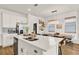 Bright kitchen boasts white cabinetry, stainless appliances, and island with seating, perfect for casual dining at 2320 Treasure Hill St, Clermont, FL 34715