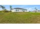 Home's backyard showcases a modern white exterior and lush, green landscaping at 2436 Sw 155Th Ln, Ocala, FL 34473