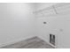Bright laundry room features gray wood-look flooring, utility sink hookups, shelving, and white walls at 2436 Sw 155Th Ln, Ocala, FL 34473