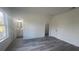 Bright bedroom features a large window, gray wood floors, an ensuite bathroom, and a walk-in closet at 245 Marion Oaks Golf Rd, Ocala, FL 34473