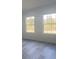 Bedroom with gray wood floors has two large windows providing lots of natural light at 245 Marion Oaks Golf Rd, Ocala, FL 34473