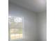 Bright bedroom features a neutral color palette, luxury vinyl flooring, and a window for natural light at 245 Marion Oaks Golf Rd, Ocala, FL 34473