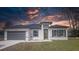 A modern single-story home displaying its gray garage door, modern front door, and landscaped front yard at 245 Marion Oaks Golf Rd, Ocala, FL 34473
