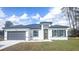 Charming single-story home showcasing a gray garage door, modern front door, and well-manicured lawn at 245 Marion Oaks Golf Rd, Ocala, FL 34473