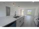 Kitchen island featuring a sink and dishwasher with seating, stone countertop, and view of open concept living area at 245 Marion Oaks Golf Rd, Ocala, FL 34473