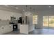 A bright kitchen features white cabinets, modern stainless appliances, kitchen island with a black faucet, and pendant lights at 245 Marion Oaks Golf Rd, Ocala, FL 34473