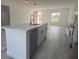 Kitchen island with sink and dishwasher features white cabinets, stone countertops, and view into the open concept living area at 245 Marion Oaks Golf Rd, Ocala, FL 34473