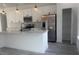 Modern kitchen features white cabinets, stainless steel appliances and an island with a sink and white countertop at 245 Marion Oaks Golf Rd, Ocala, FL 34473