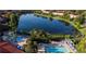 Aerial view of lake surrounded by community with resort pools and patio areas at 3008 Secret Lake Dr, Kissimmee, FL 34747