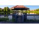 Gazebo overlooking lake with reflection of trees and other buildings at 3008 Secret Lake Dr, Kissimmee, FL 34747
