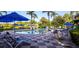 Swimming pool area with chairs and tables with blue umbrellas at 3008 Secret Lake Dr, Kissimmee, FL 34747