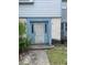 Charming townhome entrance with blue door frame and weathered white front door, palm on left at 3071 George Mason Ave # A, Winter Park, FL 32792