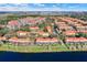 Expansive aerial view of the housing community with red tile roofs, mature trees, and manicured green spaces at 3154 Yellow Lantana Ln, Kissimmee, FL 34747