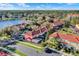 Aerial view of residences near the lake with screened patios, lush trees and landscaping, and community parking at 3154 Yellow Lantana Ln, Kissimmee, FL 34747