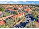 Wide aerial view of a residential community featuring townhouses with red tile roofs and ample parking spaces at 3154 Yellow Lantana Ln, Kissimmee, FL 34747