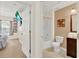 Bathroom with shower-tub combo, vanity with decorative wall art, adjacent to cozy bedroom at 3154 Yellow Lantana Ln, Kissimmee, FL 34747