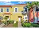 Charming two-story townhome showcasing colorful facade, white trim, and professionally landscaped front yard at 3154 Yellow Lantana Ln, Kissimmee, FL 34747
