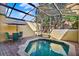 Private backyard spa with screened enclosure, outdoor seating, and lush greenery at 3154 Yellow Lantana Ln, Kissimmee, FL 34747